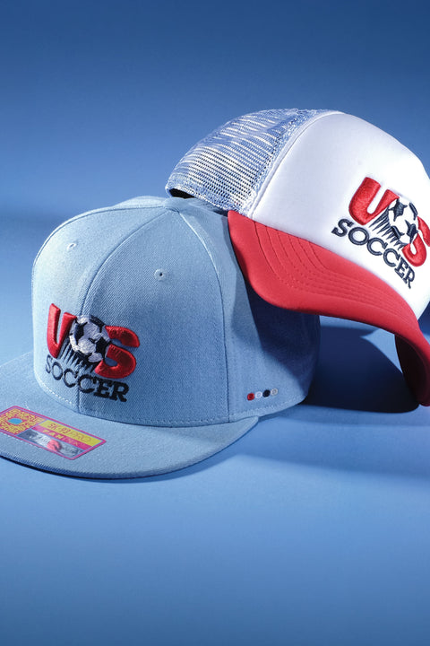 Three US Soccer hats by Fan Ink on a blue background.